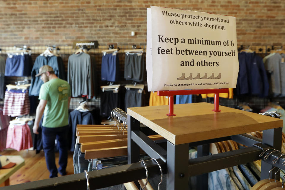 A sign reminding customers of social distancing is posted in the Bink's Outfitters store Wednesday, April 29, 2020, in Murfreesboro, Tenn. Retailers in 89 of Tennessee's 95 counties were allowed to reopen Wednesday with restrictions as the state begins the next wave of reopening its economy during the coronavirus pandemic. (AP Photo/Mark Humphrey)