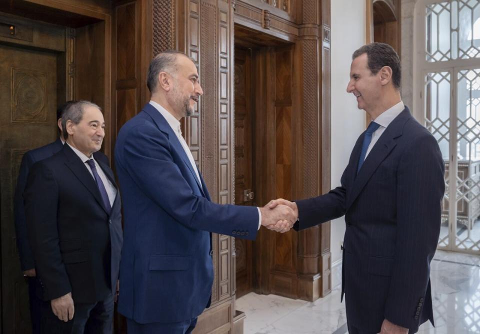 President Bashar Assad, right, met Iranian Foreign Minister Hossein Amirabdollahian after the strike on Damascus. (AP)