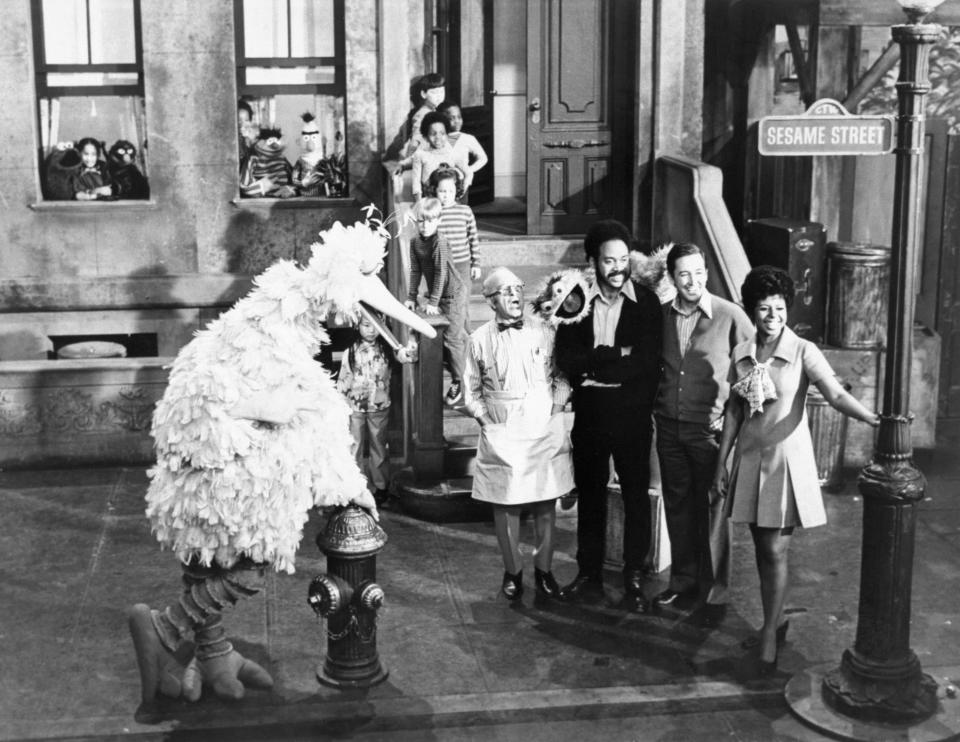 Big Bird, Mr. Hooper, Gordon, Oscar the Grouch, Bob and Susan pose at the now-famous 123 Sesame Street, after it was confirmed that the show was greenlit for a second season, which premiered on Nov. 9, 1970.