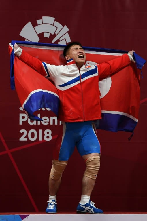 Gold medallist O Kang Chol of North Korea celebrates during the victory ceremony of the men's 69kg weightlifting event during the 2018 Asian Games in Jakarta on August 22, 2018