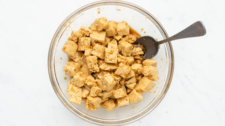 Cubed tofu marinating in bowl