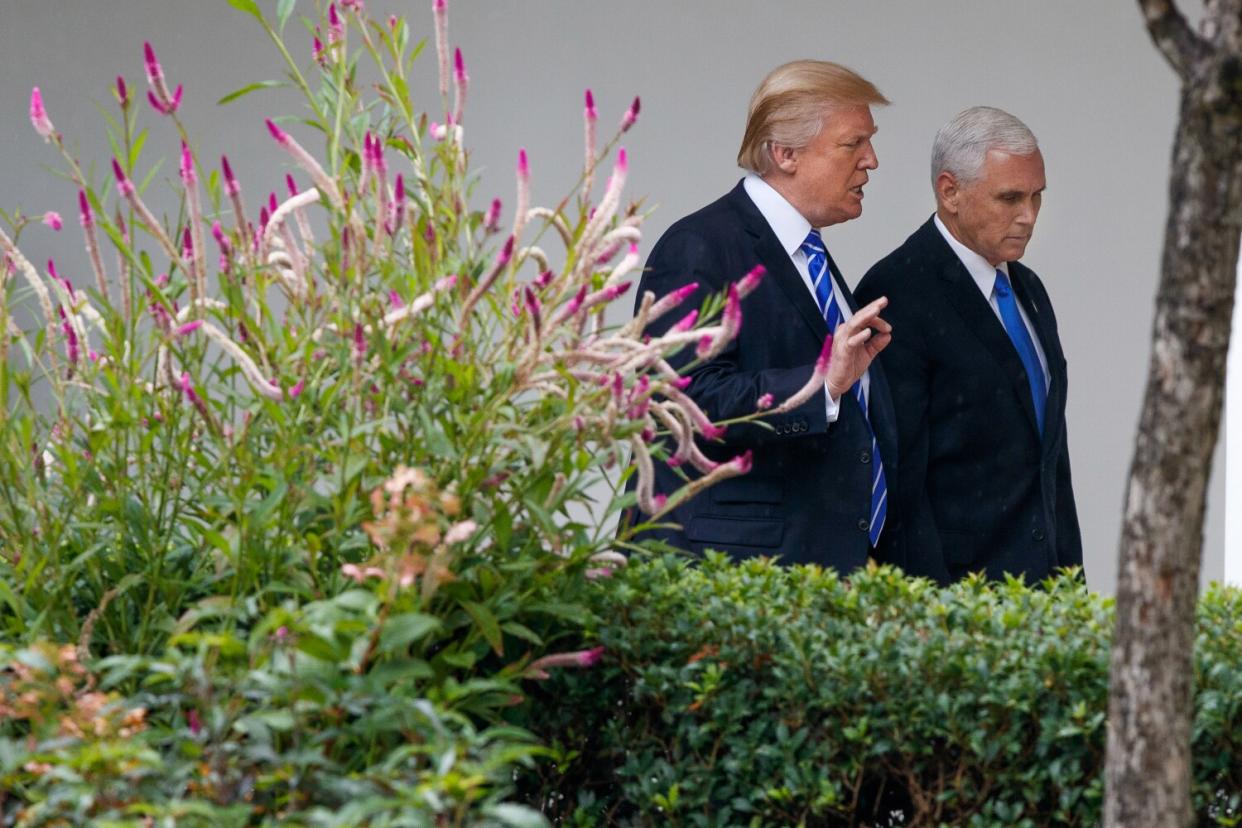 President Trump walks with Vice President Mike Pence at the White House.