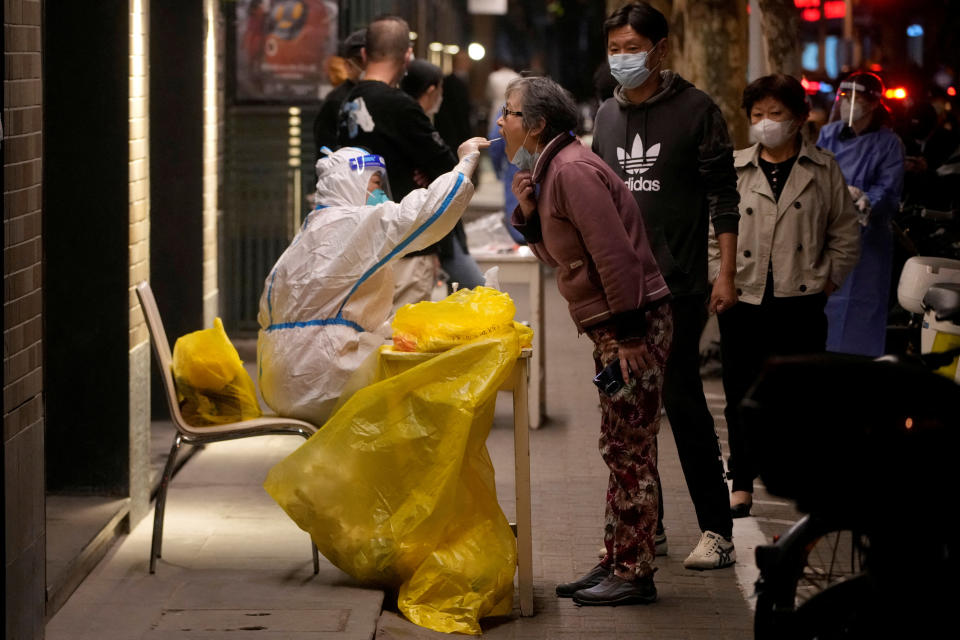   Un travailleur médical en combinaison de protection prélève un écouvillon d'un résident pour un test d'acide nucléique, à la suite de l'épidémie de maladie à coronavirus (COVID-19) à Shanghai, en Chine, le 13 octobre 2022. REUTERS/Aly Song