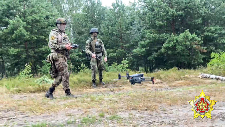 In this photo taken from video and released by Belarus' Defense Ministry on Thursday, July 20, 2023, A Belarusian soldier of the Special Operations Forces (SOF) and a mercenary fighter from Wagner private military company use a drone during the weeklong maneuvers that will be conducted at a firing range near the border city of Brest, Belarus. Mercenaries from Russia's military company Wagner have launched joint drills with the Belarusian military near the border with Poland following their relocation to Belarus after their short-lived rebellion. (Belarus' Defense Ministry via AP)
