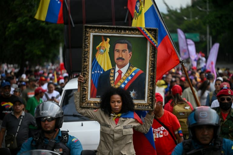 Un simpatizante sostiene un retrato del presidente venezolano Nicolás Maduro durante una manifestación convocada por el partido gobernante dos meses después de las disputadas elecciones presidenciales en Caracas el 28 de septiembre de 2024 (Federico PARRA)