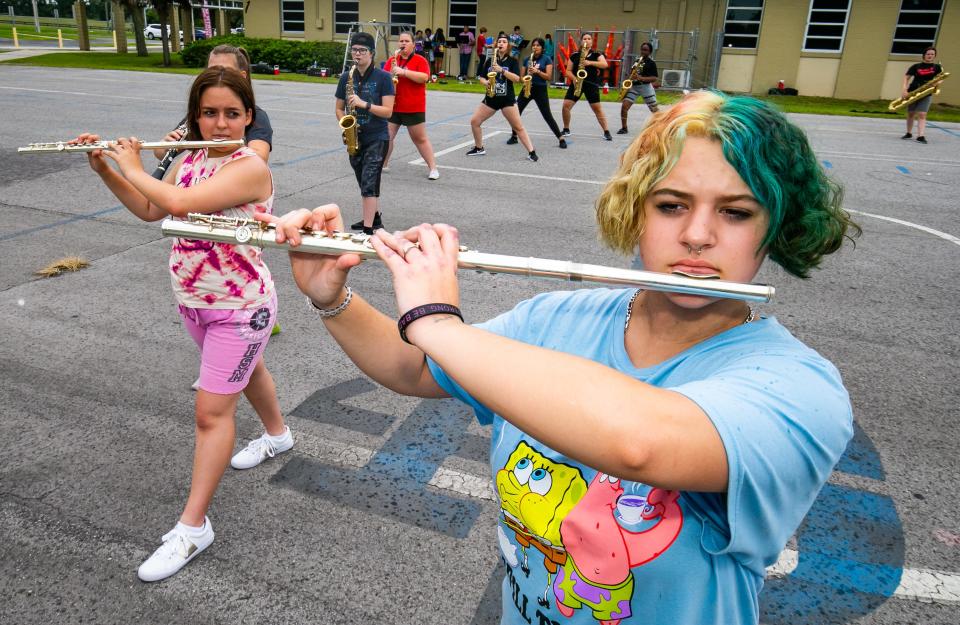North Marion High School marching band flutists Libnny Vasquez, left and Nova Lopez, right, practice with the rest of their band members last August. [Doug Engle/Ocala Star Banner]2021