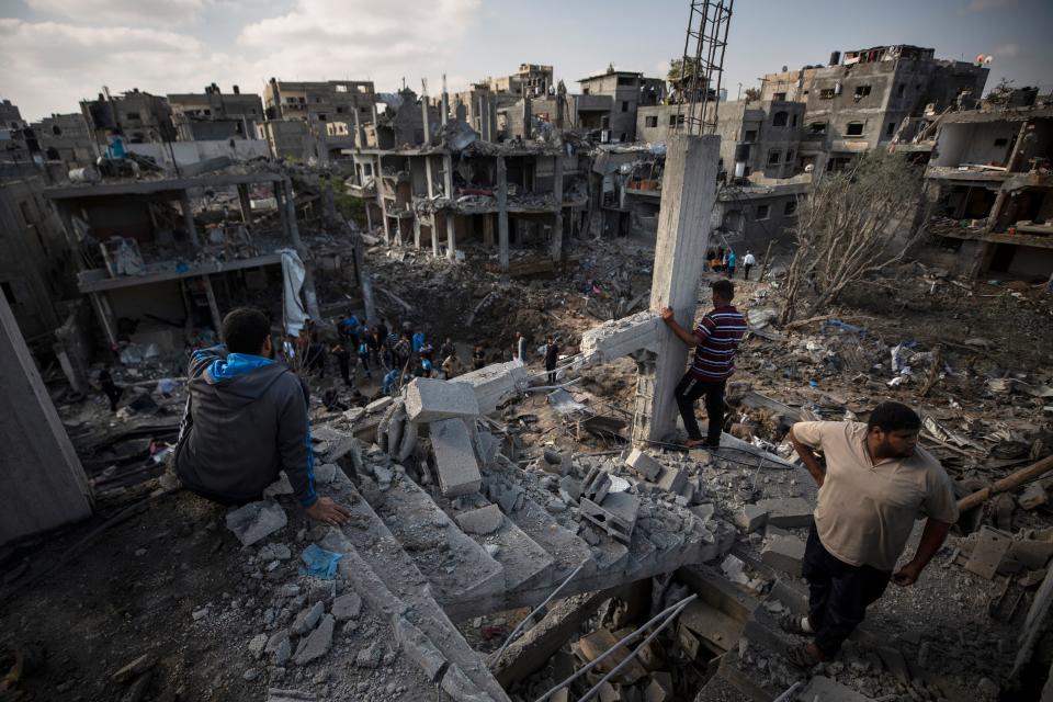 Palestinians inspect their destroyed houses following overnight Israeli airstrikes in Beit Hanoun, northern Gaza Strip, Friday, May 14, 2021.