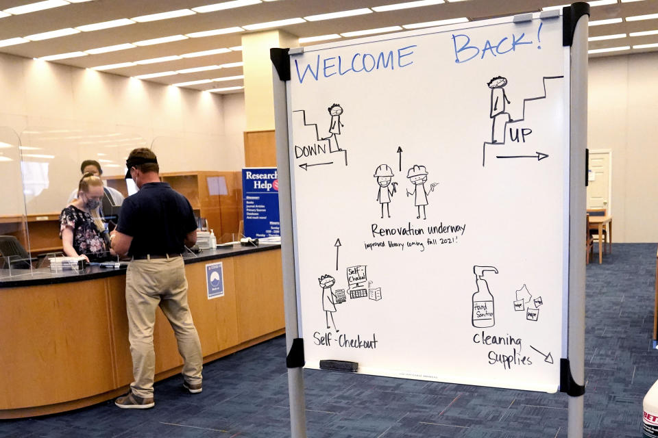 Social distancing rules are seen on a whiteboard near the entrance to the Nimitz Library at the U.S. Naval Academy, Monday, Aug. 24, 2020, in Annapolis, Md. Under the siege of the coronavirus pandemic, classes have begun at the Naval Academy, the Air Force Academy and the U.S. Military Academy at West Point. But unlike at many colleges around the country, most students are on campus and many will attend classes in person. (AP Photo/Julio Cortez)
