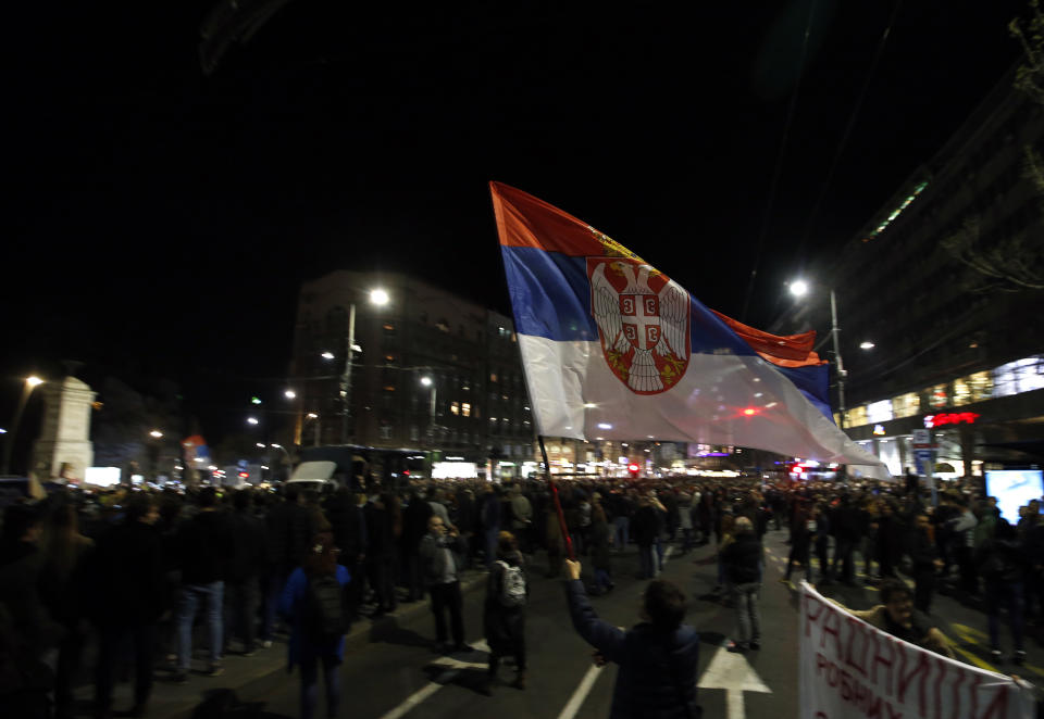 A man holds a Serbian flag during a protest at Belgrade's Terazije square, Serbia, Saturday, March 9, 2019. The demonstrations in Serbia have lasted for three months seeking more democracy in the Balkan country that is firmly under control of the populist leader Aleksandar Vucic. (AP Photo/Darko Vojinovic)