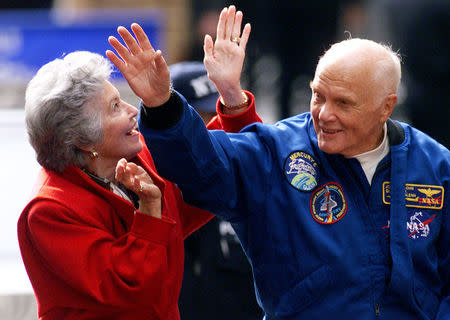 Astronaut John Glenn waves to the cheering crowd as he rides in an open car with his wife Annie during a ticker tape parade down New York's "Canyon of Heroes" on lower Broadway in New York, U.S. on November 16, 1998. REUTERS/Mike Segar/File Photo