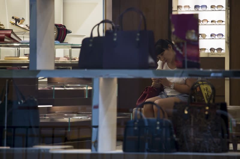 A Chinese tourist sits inside a luxury store at Hong Kong's shopping district Causeway Bay, China