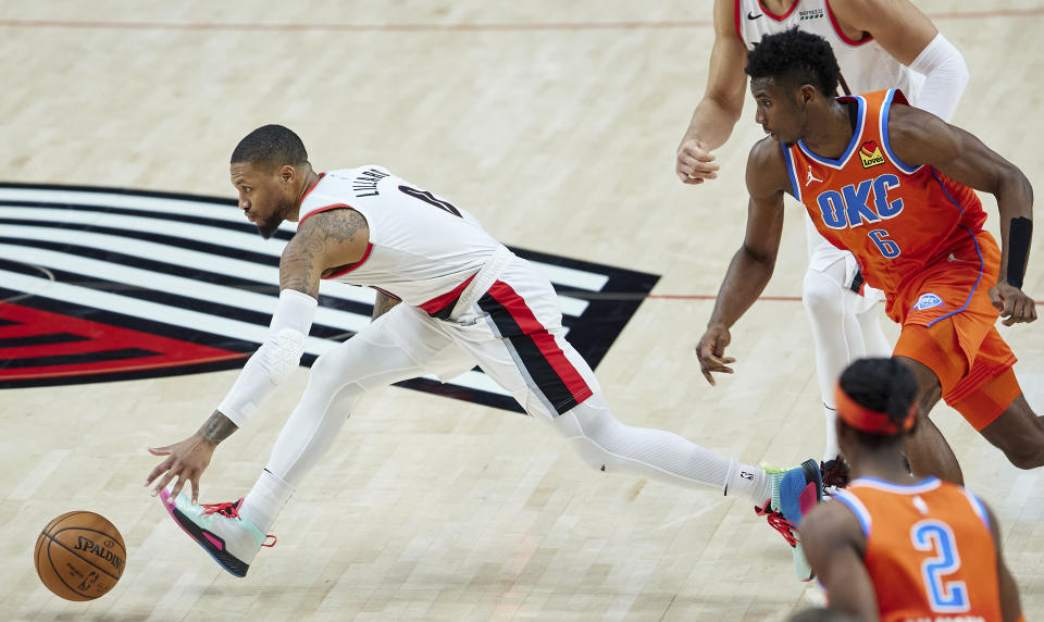 Portland Trail Blazers guard Damian Lillard, left, runs after the ball in front of Oklahoma City Thunder guard Hamidou Diallo during the first half of an NBA basketball game in Portland, Ore., Monday, Jan. 25, 2021. (AP Photo/Craig Mitchelldyer)