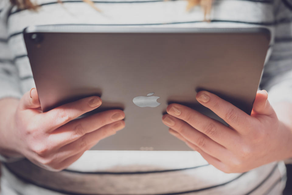 Photographed in London on the 17th November 2018 Showing the new Apple iPad Pro 12.9 Inch tablet computer recently launched by Apple at their November event in New York. The image shows the back of the iPad while held by a woman with a stripy t-shirt on.