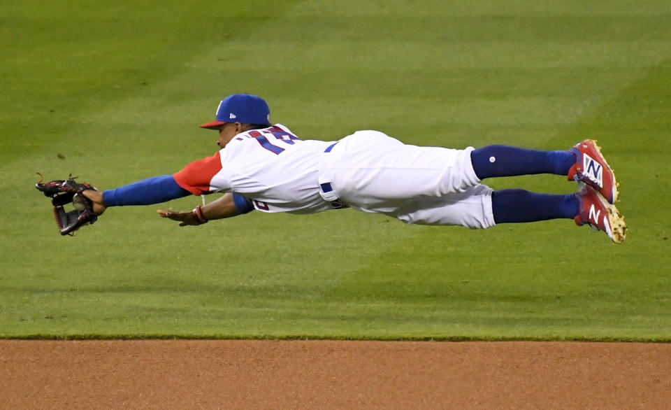 El torpedero de Puerto Rico Francisco Lindor fildea un rodado de hit de Andrew McCutchen de Estados Unidos en el quinto inning de la final del Clásico Mundial de Béisbol, el miércoles 22 de marzo de 2017. (AP Foto/Mark J. Terrill)