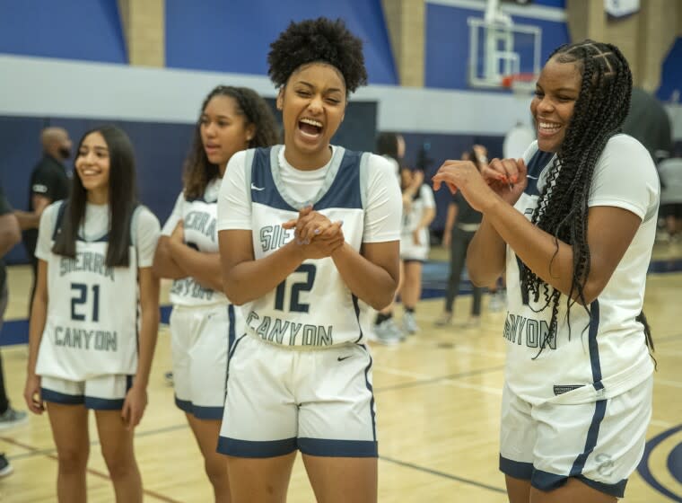 CHATSWORTH, CA - OCTOBER 27, 2021: Juju Watkins, foreground, left and Mac Randolph, right, members of the Sierra Canyon girls basketball team, share a light moment together during media day inside the school's gymnasium. (Mel Melcon / Los Angeles Times)