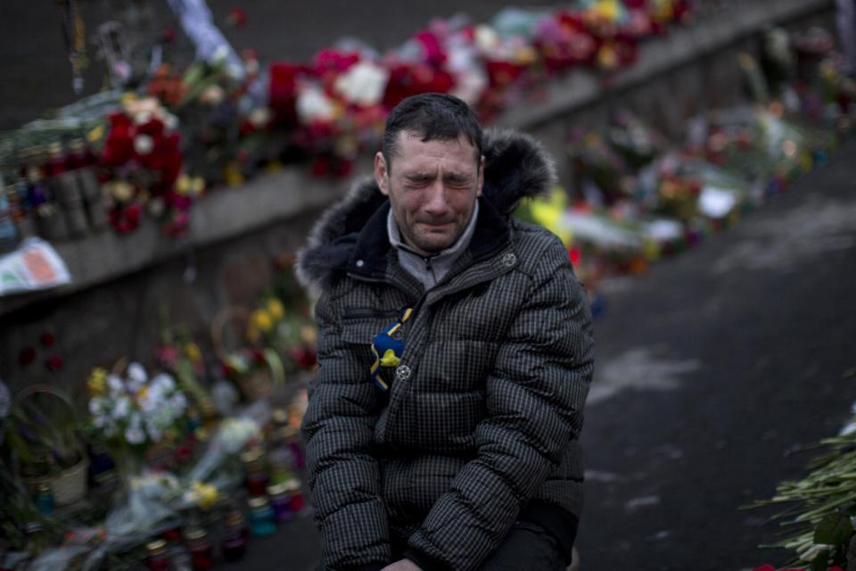 Un hombre llora en el siitio donde su hermano fue asesinado durante un enfrentamiento con la policía antidisturbios en la Plaza de la Independencia de Kiev, Ucrania, el viernes 28 de febrero de 2014. (Foto AP/Emilio Morenatti)