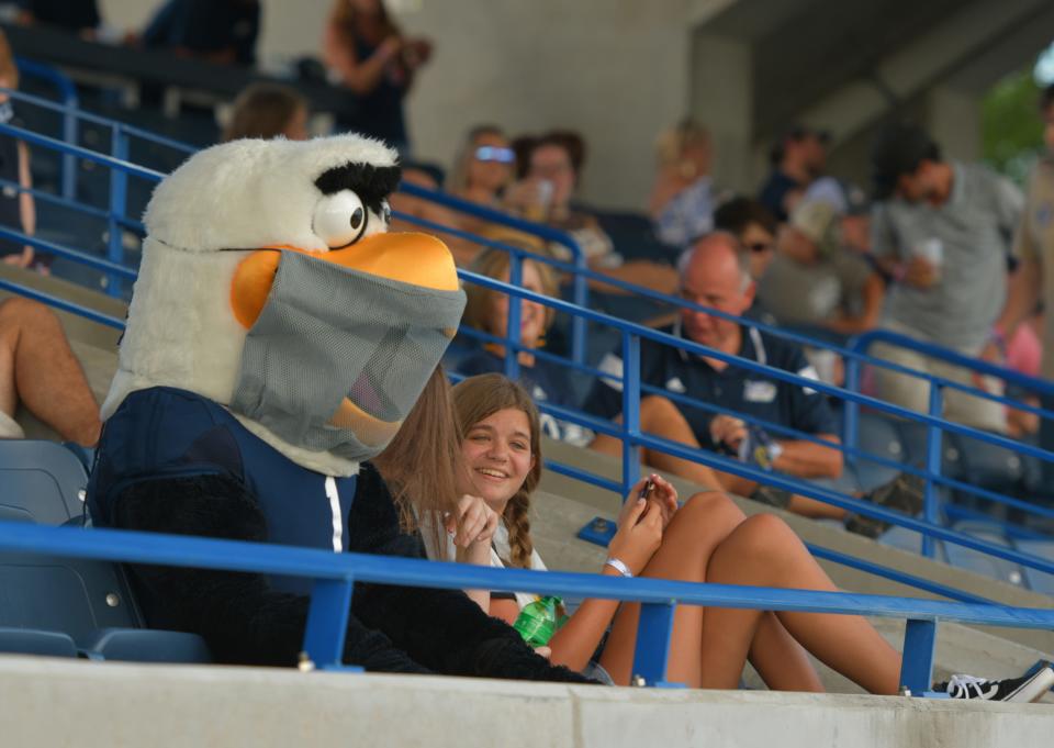 Mask-wearing Georgia Southern mascot Gus cozies up to a couple of fans during the Eagles' football season opener against Campbell at Paulson Stadium on Saturday.
