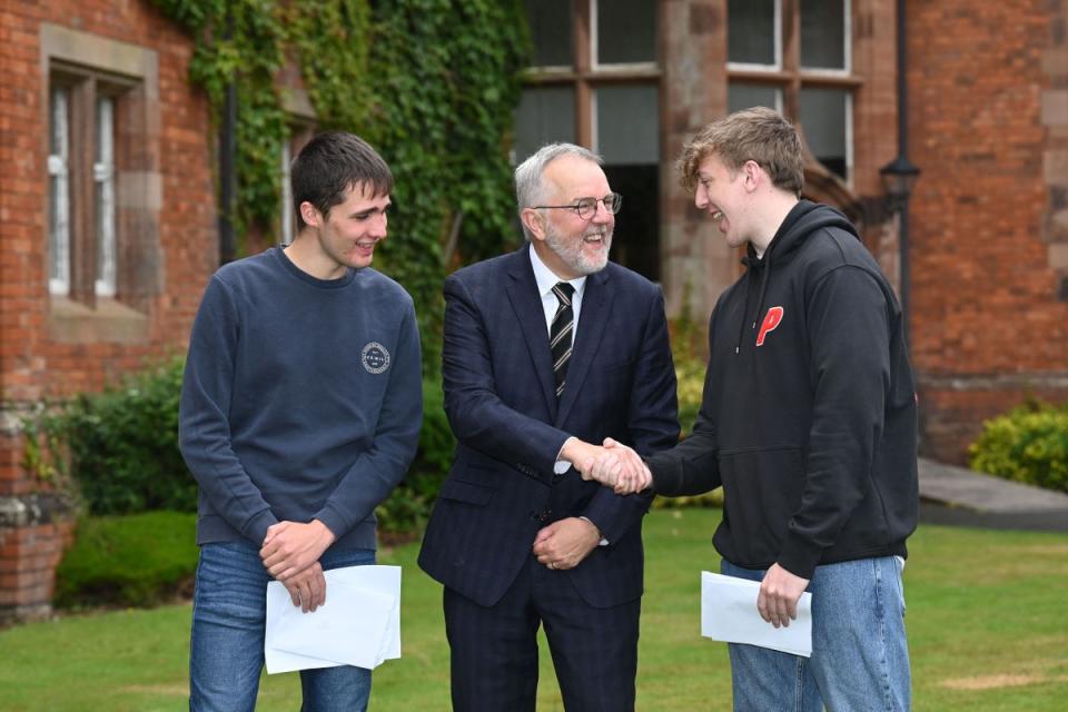 Campbell College headmaster Robert Robinson congratulates A-level students Patrick Kenny and Tom Crowther (Michael Cooper/PA) (PA Media)