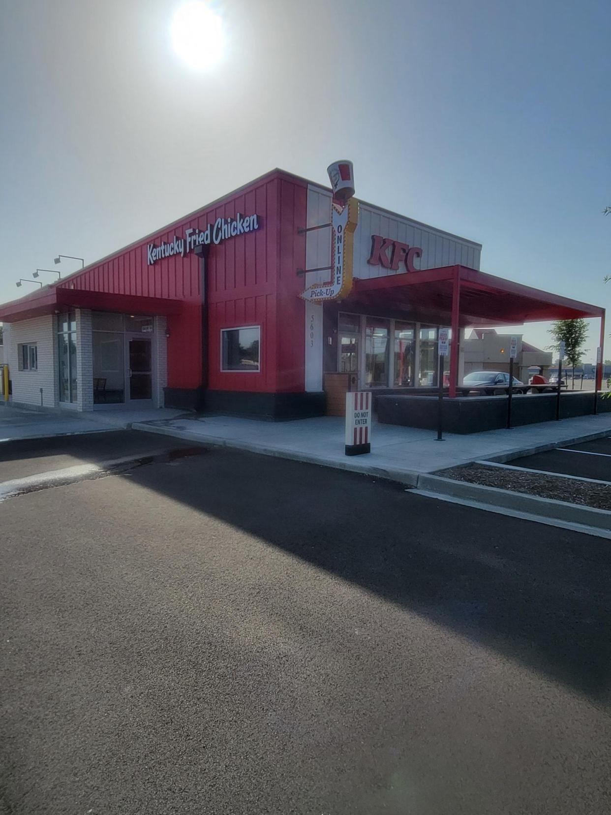 The "Next Gen" KFC store offers new features including a brightly lit red bucket pointing to an entrance just for pick up orders and dedicated parking spots for online orders.