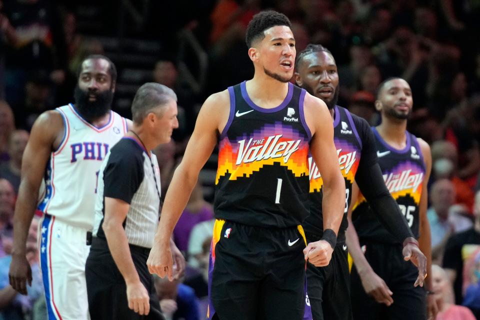 Phoenix Suns guard Devin Booker (1) reacts to the Philadelphia 76ers bench during the first half of an NBA basketball game, Sunday, March 27, 2022, in Phoenix.