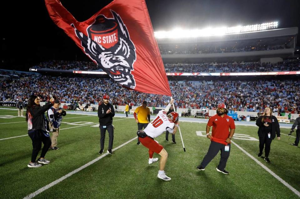 N.C. State quarterback Ben Finley (10) plants the flag in the turf after N.C. State’s 30-27 overtime victory over UNC at Kenan Stadium in Chapel Hill, N.C., Friday, Nov. 25, 2022.