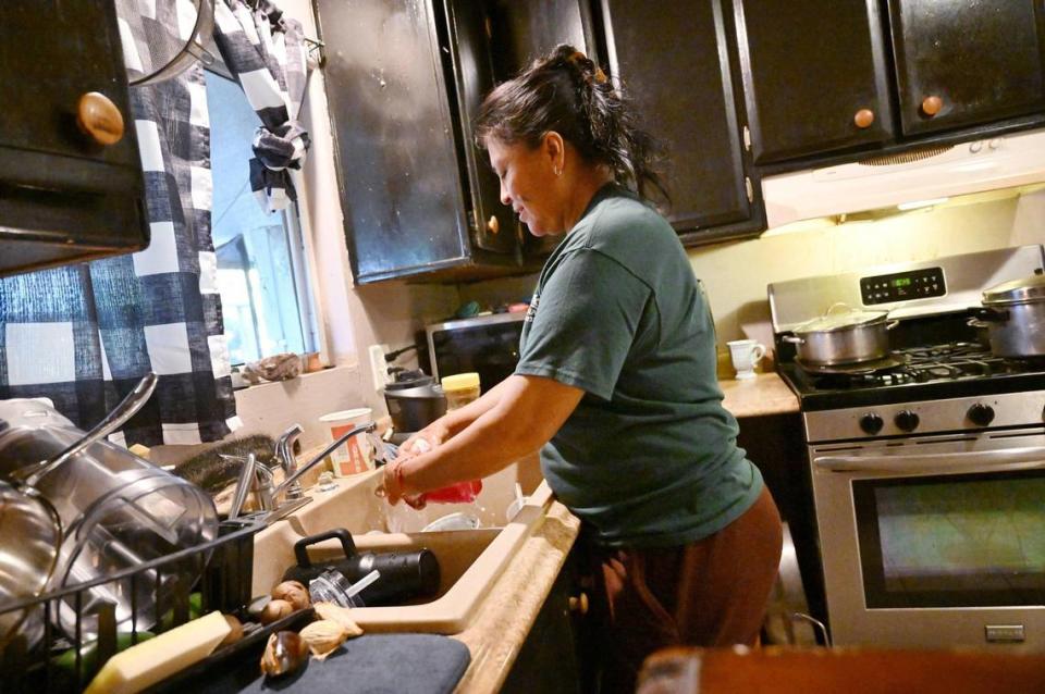 Xochilt Nuñez, who immigrated from Mexico in 1999, washes dishes at her home in an Orosi, small town 45 minutes from Fresno, on March 26. Nunez has spent years advocating for farmworker and immigrant rights and yet describes frustration and anger with the recent waves of migrants.