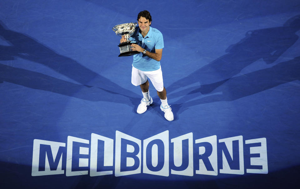 FILE - Roger Federer of Switzerland holds the trophy after beating Andy Murray of Britain to win the Men's singles final match at the Australian Open tennis championship in Melbourne, Australia, Sunday, Jan. 31, 2010. Federer announced Thursday, Sept.15, 2022 he is retiring from tennis. (AP Photo/Andrew Brownbill, File)