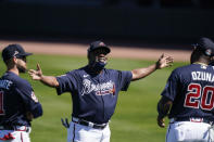 Atlanta Braves first base coach Eric Young talks with Marcell Ozuna (20) and Ender Inciarte (11) during spring training baseball practice on Tuesday, Feb. 23, 2021, in North Port, Fla. (AP Photo/Brynn Anderson)