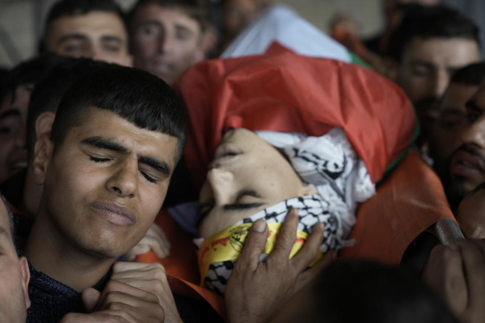 Palestinian mourners carry the body of Akram Dweikat, 17, killed in clashes with Israeli forces, during his funeral in the West Bank city of Nablus, Sunday, Oct. 15, 2023. (AP Photo/Majdi Muhammad)
