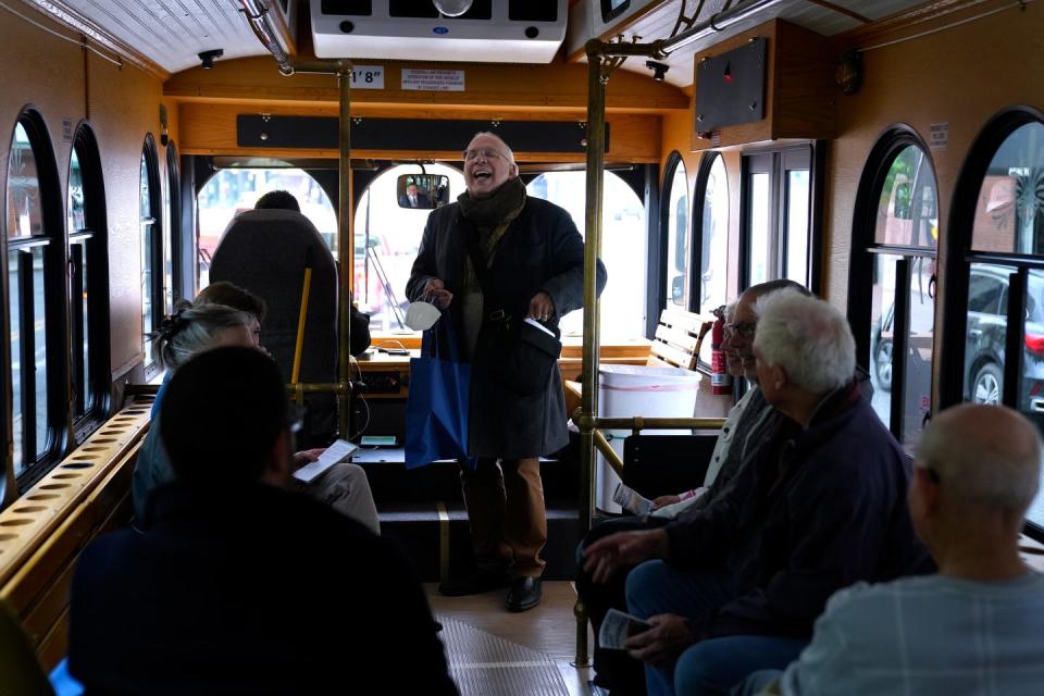 Tour guide Frank Toti shares historical tidbits of downtown buildings and murals as he begins a Gallery Night Providence trolley tour last week.