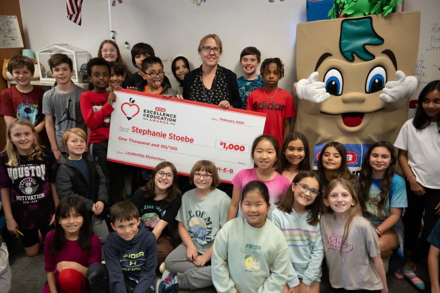 Stephanie Stoebe holds the H-E-B excellence award with students (Photo provided by H-E-B). 