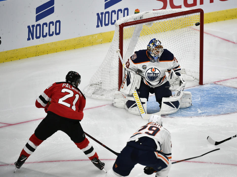 New Jersey Devils' Kyle Palmieri, left, scores, during the season-opening NHL Global Series hockey match between Edmonton Oilers and New Jersey Devils at Scandinavium in Gothenburg, Sweden, Saturday, Oct. 6, 2018, (Bjorn Larsson Rosvall /TT News Agency via AP)