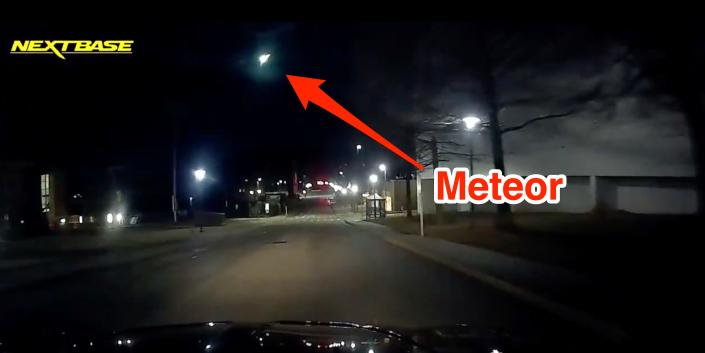 A car dashboard camera captures a meteor in the sky. A superimposed red arrow points to the meteor.