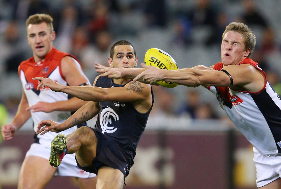 MELBOURNE, AUSTRALIA - MAY 05:  Jeff Garlett of the Blues his his kick smothered by Tom McDonald of the Demons during the round six AFL match between the Carlton Blues and the Melbourne Demons at Melbourne Cricket Ground on May 5, 2013 in Melbourne, Australia.  (Photo by Michael Dodge/Getty Images)