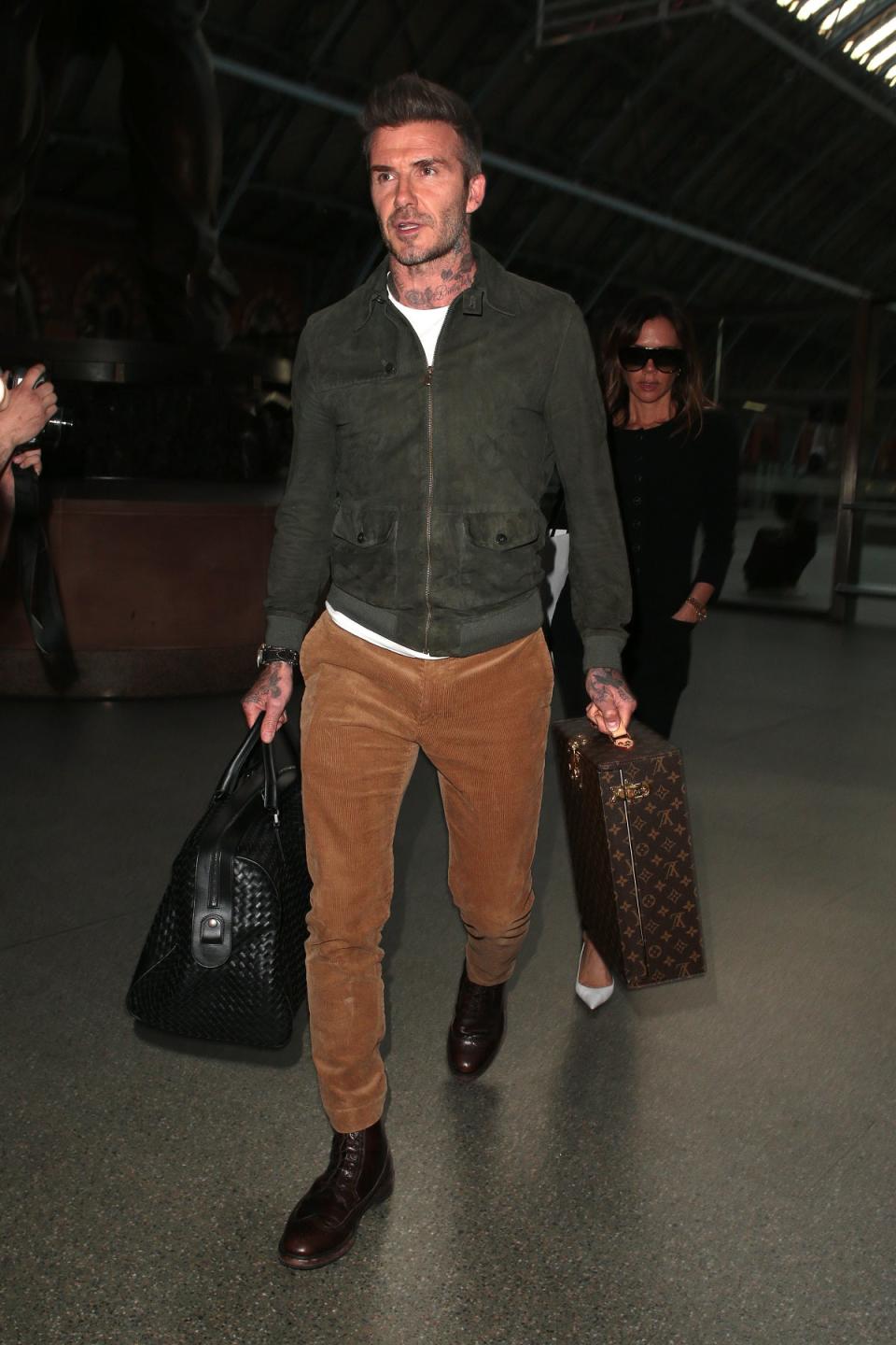 David Beckham  carrying Louis Vuitton and Bottega Veneta luggage (GC Images)