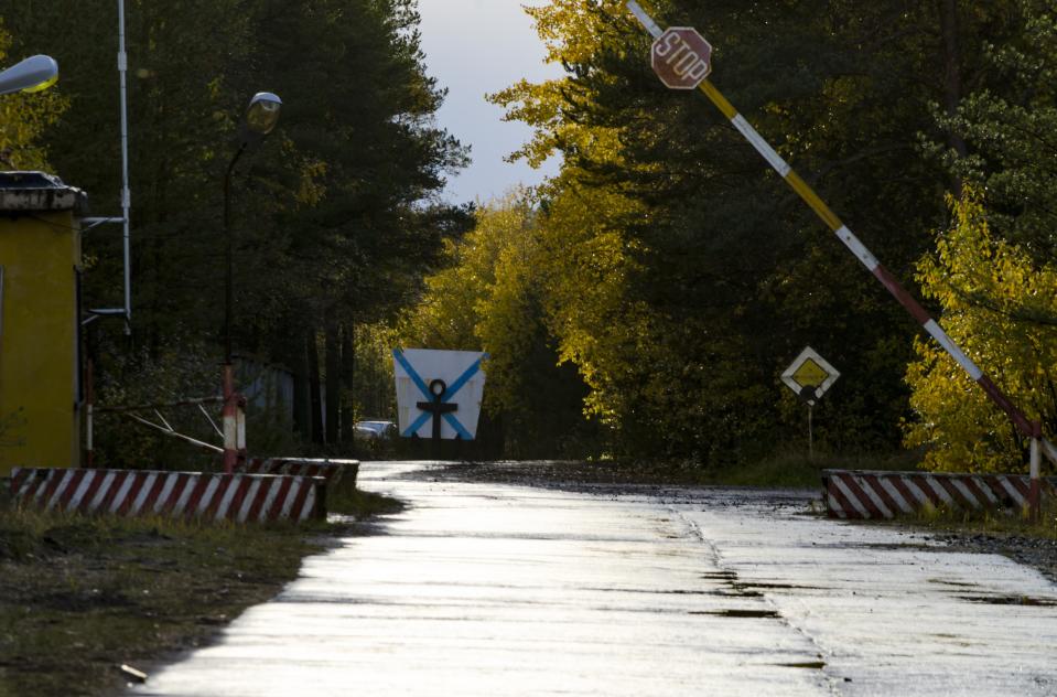 FILE - This Sunday, Oct. 7, 2018 file photo, shows an entrance to "The State Central Navy Testing Range" near the village of Nyonoksa, northwestern Russia. The Aug. 8, 2019, explosion of a rocket engine at the Russian navy's testing range just outside Nyonoksa led to a brief spike in radiation levels and raised new questions about prospective Russian weapons. Over Russian 100 medical workers who helped treat victims of a recent mysterious explosion at a military testing range have undergone checks and one man has been found with a trace of radiation, officials said Friday Aug. 23, 2019. (AP Photo/Sergei Yakovlev, File)