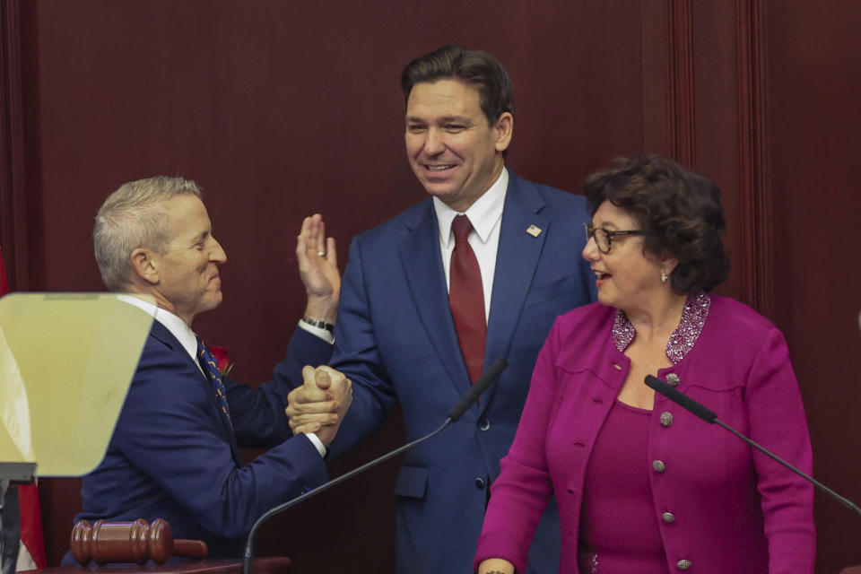 Florida Gov. Ron DeSantis is welcomed to a joint session of the Senate and House of Representatives by House Speaker Paul Renner, R-Palm Coast, left, and Florida Senate President Kathleen Passidomo, R-Naples, right, to give his State of the State address, Tallahassee, Fla., Tuesday, Jan. 9, 2024. (AP Photo/Gary McCullough)