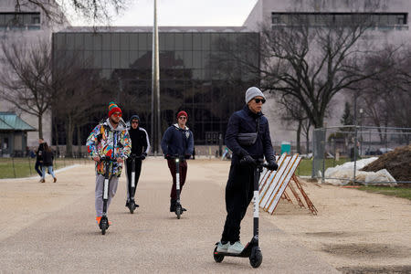 People ride on scooters outside the Smithsonian Air and Space Museum in Washington, U.S., before it will be reopen next week after partial government shutdown, January 27, 2019. REUTERS/Yuri Gripas