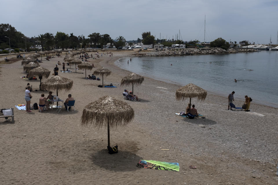 FILE - In this Sunday, May 10, 2020 file photo, people enjoy the beach of Glyfada suburb, southwest of Athens. Greece's Prime Minister Kyriakos Mitsotakis said Wednesday April 21, 2021, the country's tourism industry will open on May 15 when a ban on travel between different regions in the country will be lifted, adding that restaurants and cafes will also be allowed to reopen outdoor areas starting on May 3. (AP Photo/Yorgos Karahalis, File)