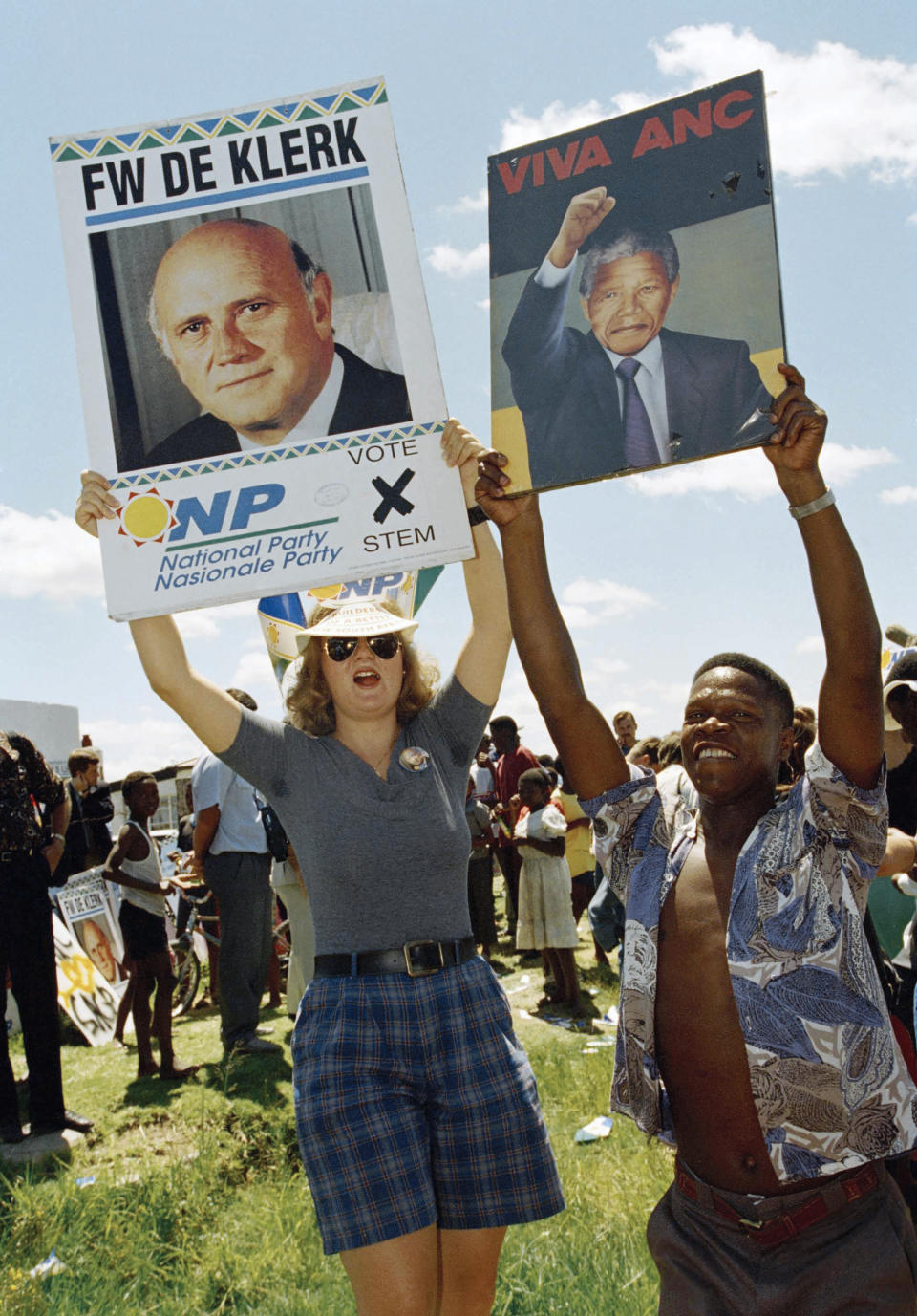 FILE - A National Party supporter, left, and a Black African National Congress supporter, with Nelson Mandela poster, try to out-shout each other, Jan. 29, 1994, in Bethal, South Africa, at an elections rally. South Africa is engrossed in debate over the legacy of apartheid's last president, F.W. de Klerk, who died at 85 and is to be buried Sunday, Nov 21, 2021. Some people want to remember de Klerk as the liberator of Nelson Mandela, but others say he was responsible for racist murders. (AP Photo/John Parkin, File)