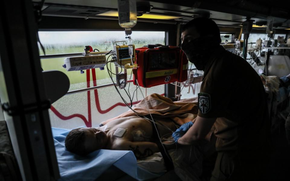 Paramedics from the international volunteer team of Hospitallers battalion give medical aid to injured serviceman - OLEG PETRASYUK/EPA-EFE/Shutterstock/Shutterstock