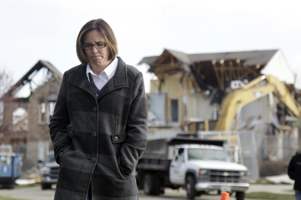 Nikki Cocherell walks away from the site where her home was being demolished in Indianapolis, Tuesday, Nov. 27, 2012. City building inspectors last week ordered the demolition of 29 houses by Dec. 20. Four other homes, including two that were leveled in the Nov. 10 explosion, are being maintained as police investigate what they believe was an intentional natural gas explosion. (AP Photo/Michael Conroy)