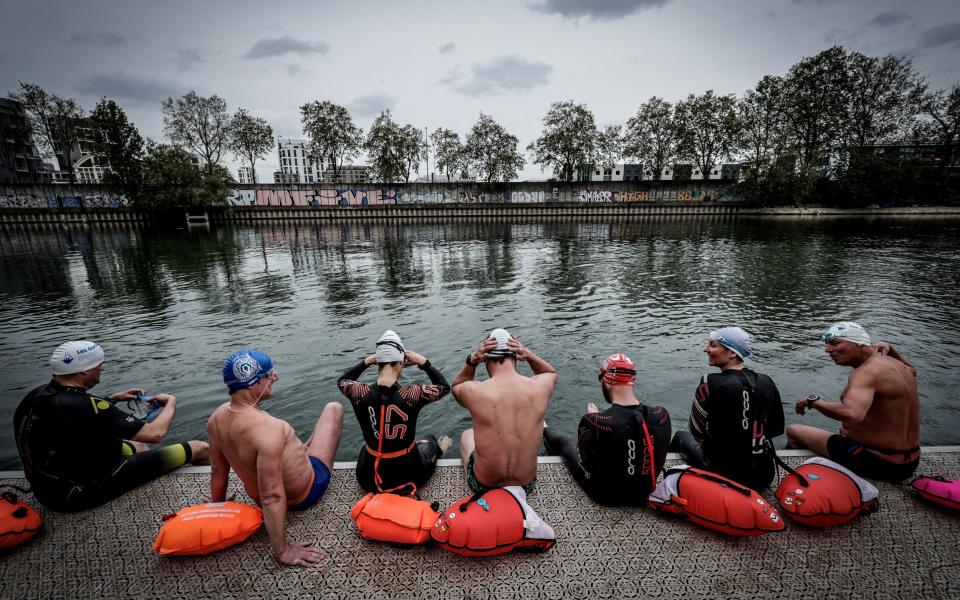 A group of swimmers prepare to enter the River Seine