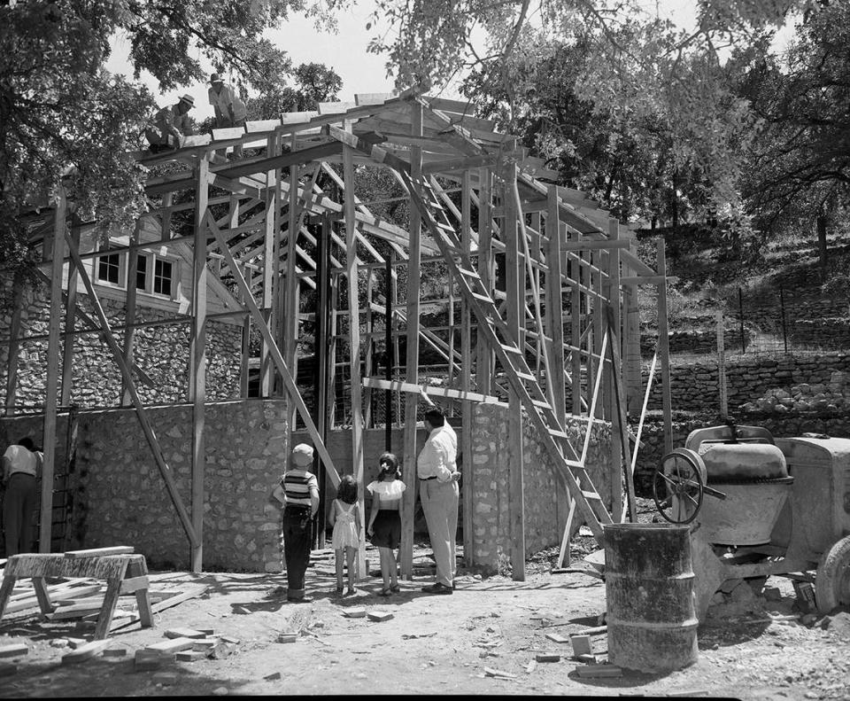 July 3, 1951: Features of the new giraffe house under construction at Forest Park Zoo in Fort Worth are pointed out by Director Ham Hittson to a trio of young visitors. Left to right are Gregory Reynolds, Ann Morrow, 4, and her sister, Lucille, 6.