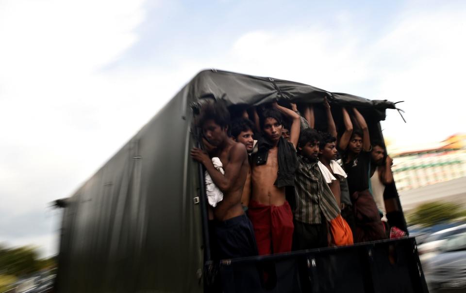 Bangladeshi migrants stand in a moving police van at the police headquarters in Langkawi on May 11, 2015 after landing on Malaysian shores earlier in the day. (MANAN VATSYAYANA/AFP/Getty Images)