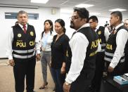 In this handout photo provided by Peru's Palace of Justice Press Office, Keiko Fujimori, the daughter of Peru's former President Alberto Fujimori and opposition leader, center, is escorted by police inside the courtroom in Lima, Peru, Tuesday, Jan. 28, 2020. A Peruvian judge ordered 15 months of preventive detention for Keiko Fujimori while she is investigated for alleged money laundering related to the Brazilian construction company Odebrecht. (Francisco Medina/Peru's Palace of Justice Press Office via AP)