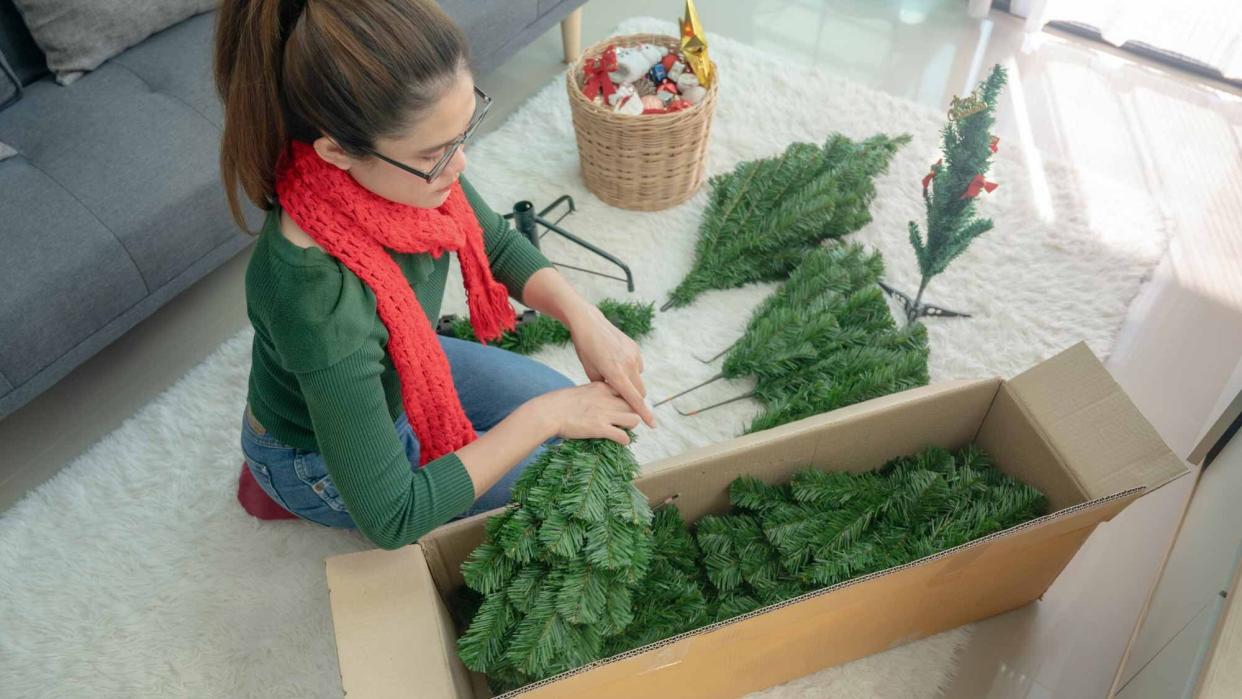  Woman packing Christmas tree. 