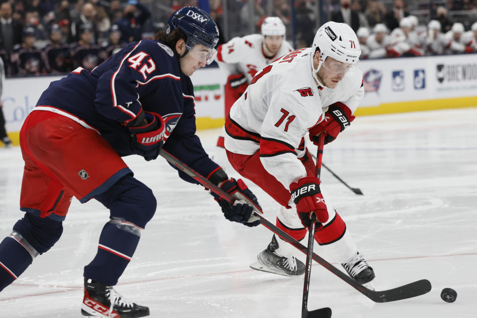 Columbus Blue Jackets' Alexandre Texier, left, tries to clear the puck past Carolina Hurricanes' Jesper Fast during the third period of an NHL hockey game Saturday, Jan. 1, 2022, in Columbus, Ohio. (AP Photo/Jay LaPrete)