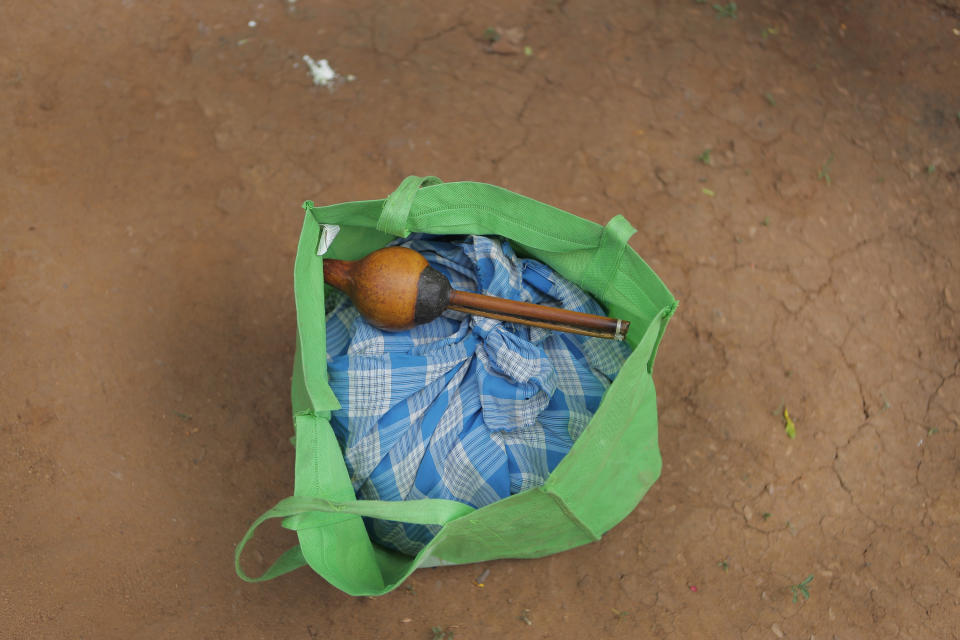 A traditional instrument lies inside a bag carrying a cobra wrapped in a sarong at a Telugu colony in Kudagama, Sri Lanka, Tuesday, June 16, 2020. Sri Lanka's Telugu community, whose nomadic lifestyle has increasingly clashed with the modern world, is facing another threat that could hasten its decline: the COVID-19 pandemic. (AP Photo/Eranga Jayawardena)