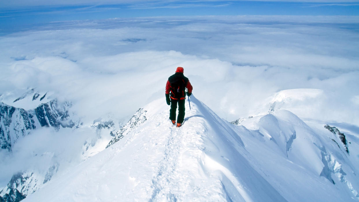  Climber on steep, exposed snowy summit of Europe's tallest peak, Mt Blanc. 